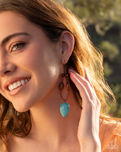 Close-up of a woman wearing turquoise earrings with a blurred natural background