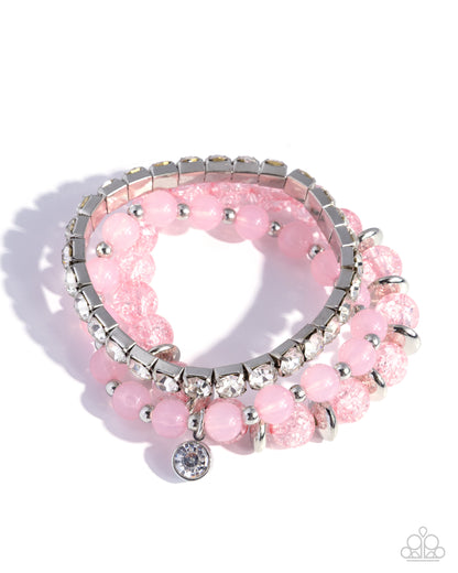 Pink beaded bracelet with silver accents on a white background