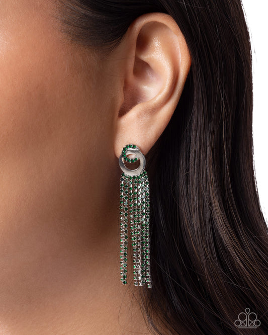 Earring with green gemstones and silver chain tassels worn by a person.