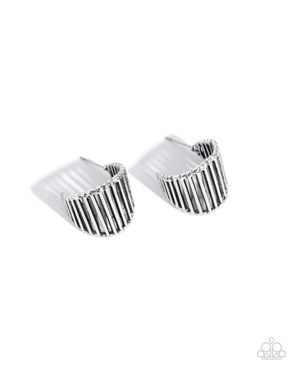 Pair of silver ring-shaped earrings on a white background