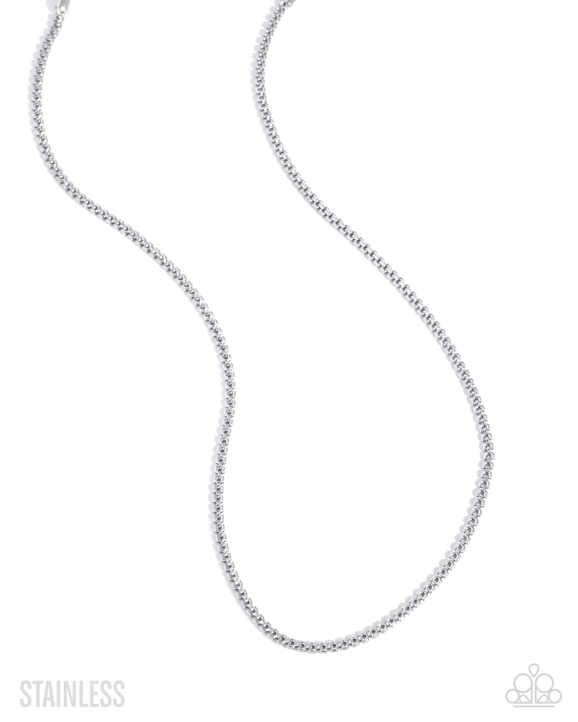 A silver stainless steel box chain necklace, shown in a curved loop shape against a plain white background, with 'STAINLESS' text in the bottom-left corner and a small logo in the bottom-right.