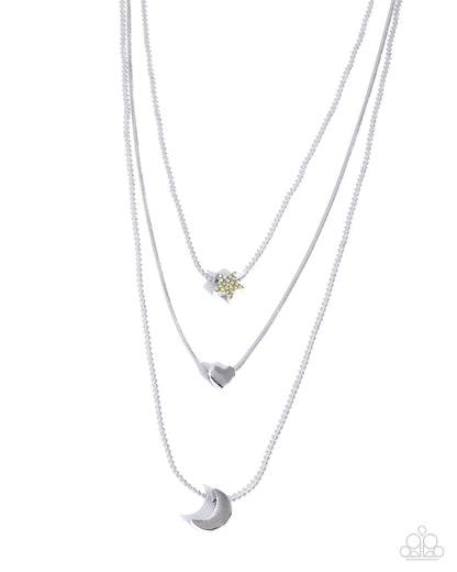 Layered necklaces with heart, star, and moon pendants on a white background