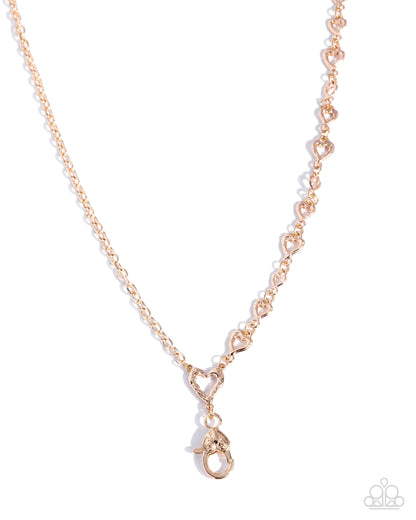 Rose gold necklace with a heart-shaped clasp on a white background