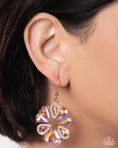 Close-up of an ear wearing a sparkling gold and purple earring.