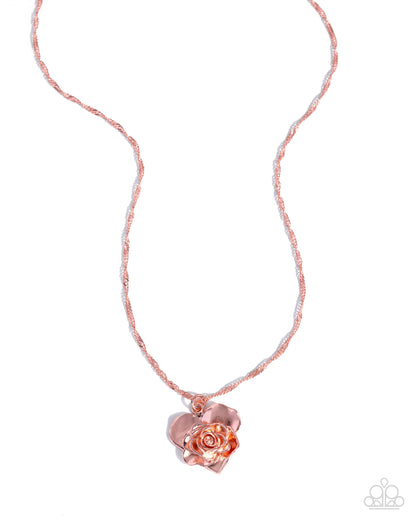 Rose gold heart-shaped pendant on a thin chain against a white background