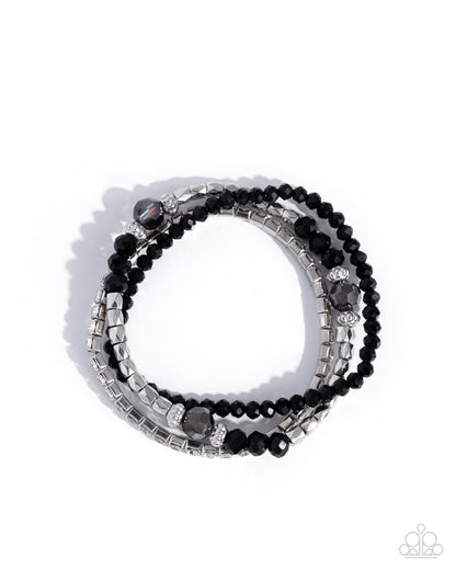 Stack of black beaded bracelets with silver accents on a white background