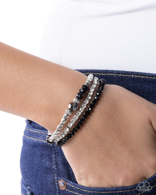 Close-up of a wrist wearing multiple bracelets on a white background