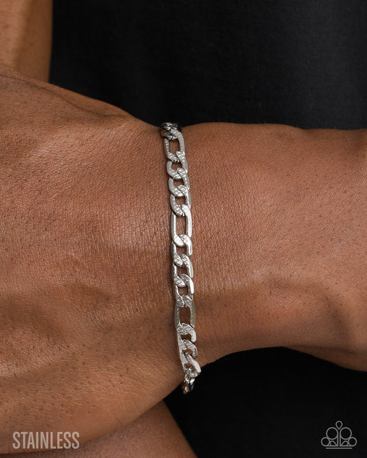 Silver chain bracelet on a wrist with 'Stainless' text at the bottom.