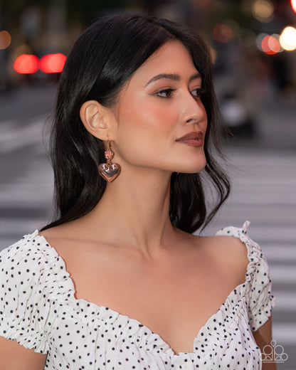 Woman wearing a white polka dot dress with a blurred city street background