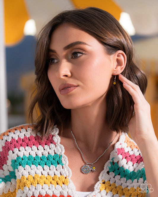 Woman wearing a colorful crochet cardigan with a blurred background