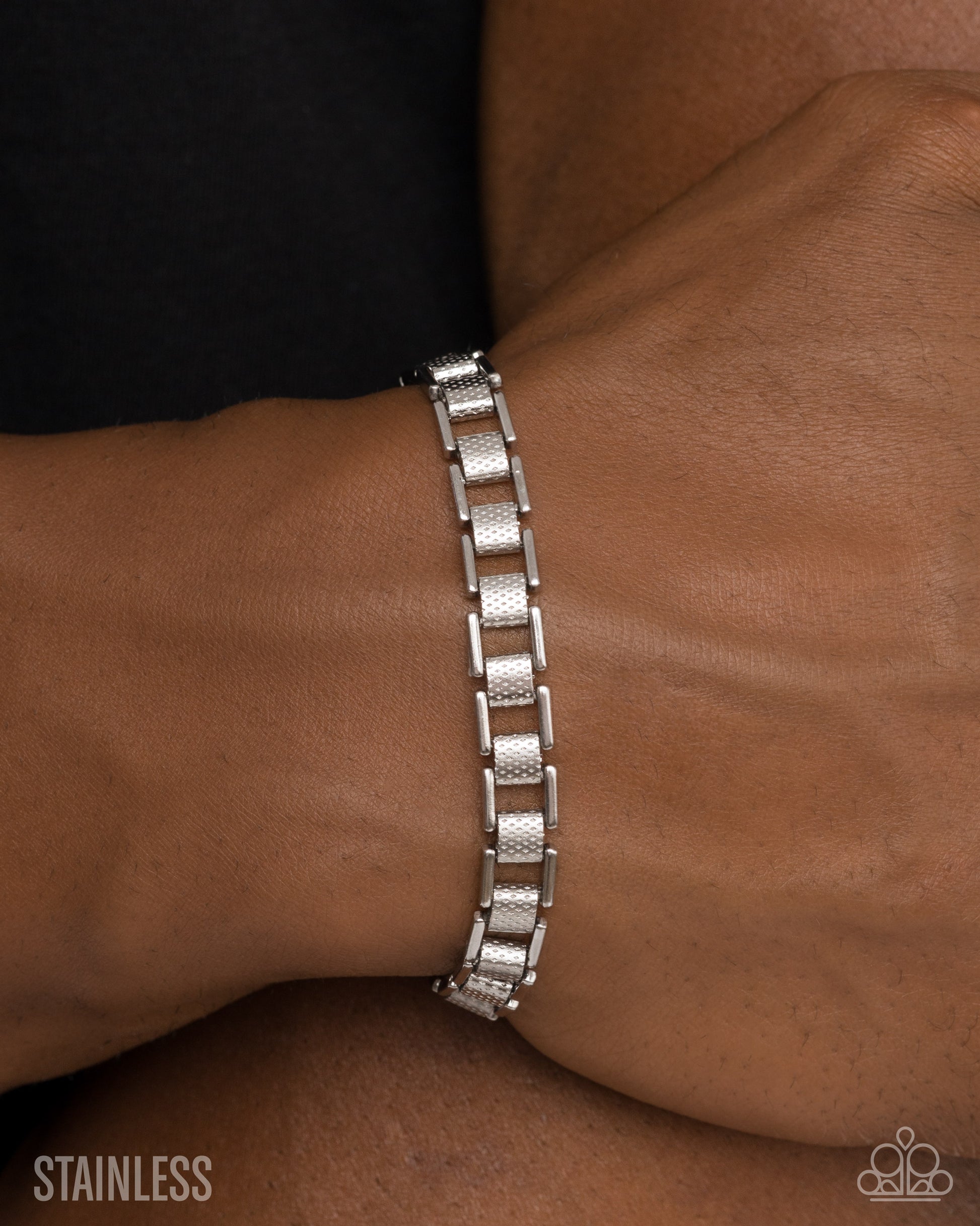 Silver bracelet on a wrist with 'Stainless' text