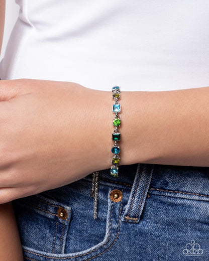 Multicolored beaded bracelet on a wrist with a white shirt and blue jeans background