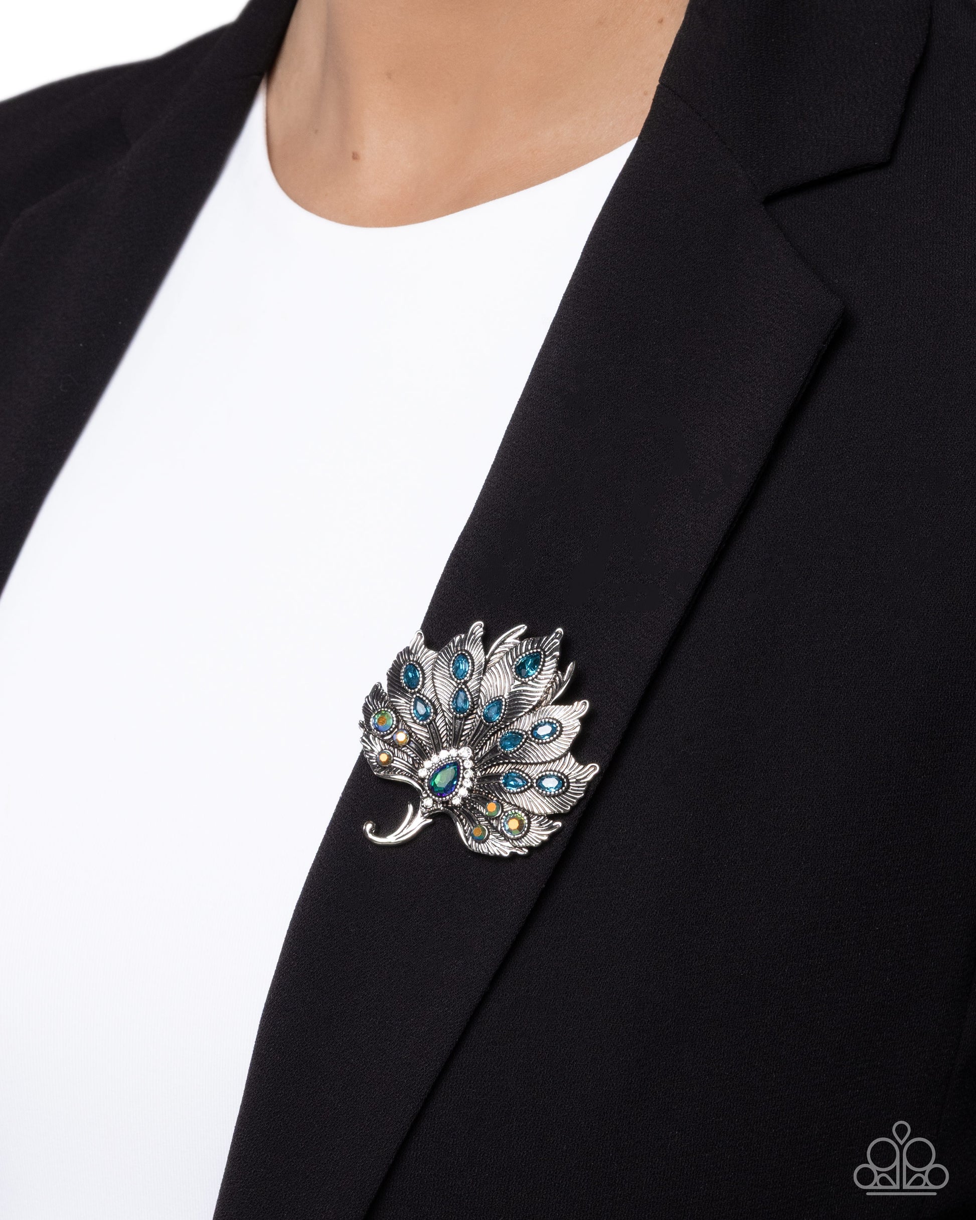 Silver brooch with blue gemstones on a black blazer