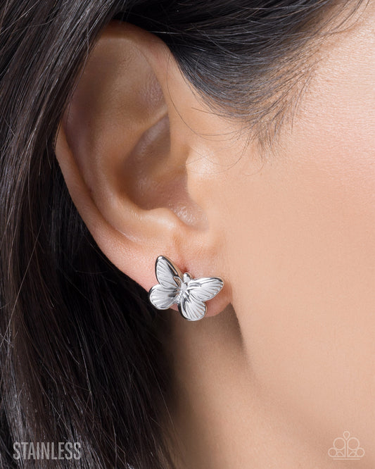 Butterfly earring worn on an ear with 'Stainless' text in the corner