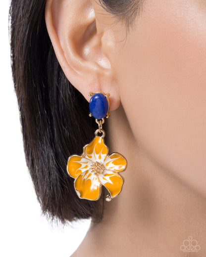A close-up of a model's ear wearing a dangling earring with a blue oval stud and a gold-tone flower drop in yellow and white enamel.