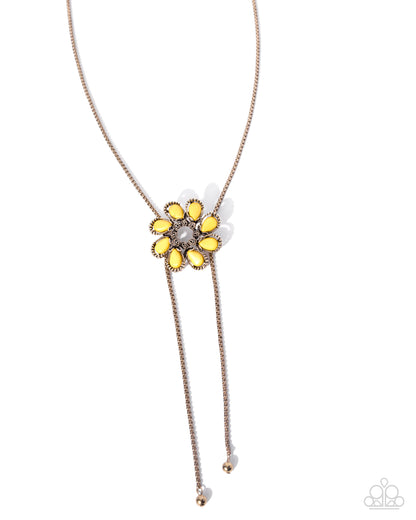 Necklace with a yellow flower-like pendant on a white background