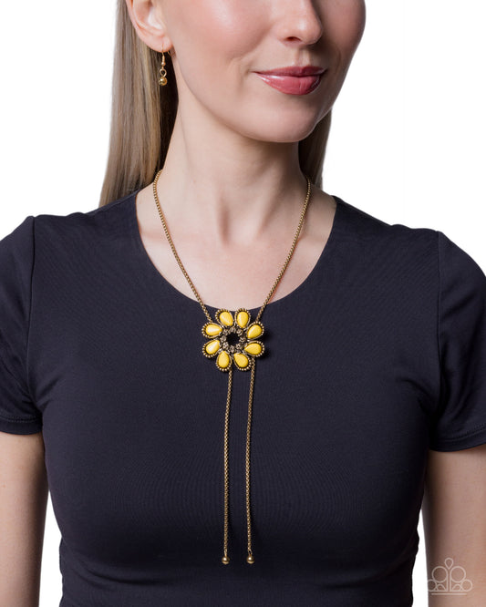 Woman wearing a black shirt with a yellow and gold necklace