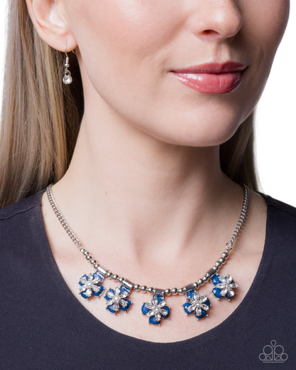 Necklace with blue flower pendants worn by a model on a white background