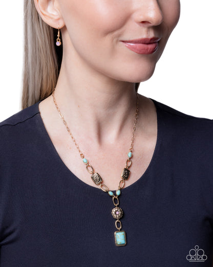 Woman wearing a turquoise necklace with a blue top against a white background