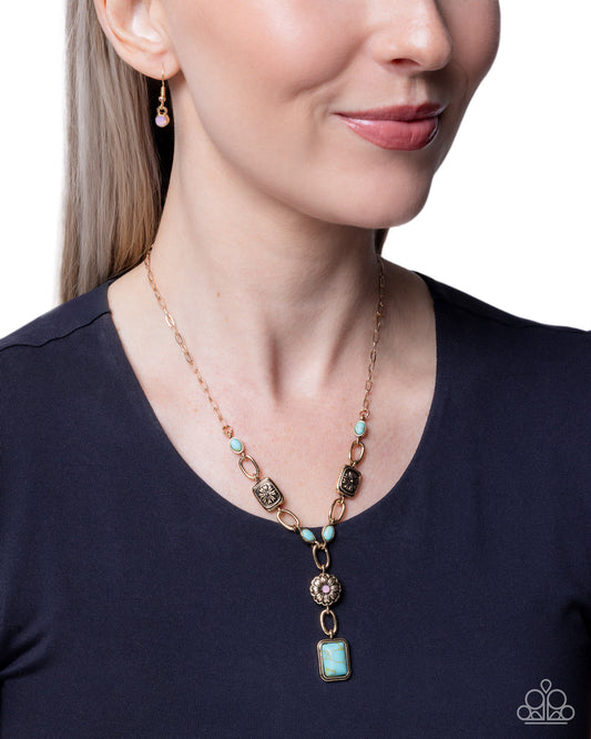 Woman wearing a turquoise necklace with a blue top against a white background