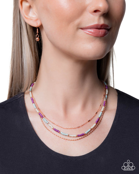 Close-up of a woman wearing a colorful beaded necklace and earrings on a plain background