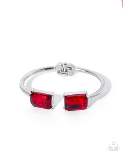 Silver bracelet with red gemstones on a white background