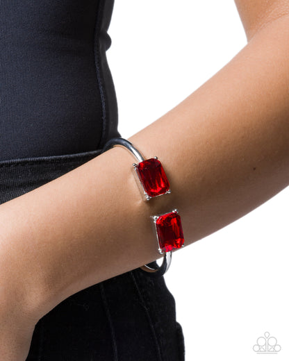 Bracelet with red gemstones on a wrist against a black background