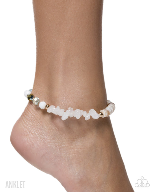 Ankle bracelet with white stones and gold accents on a white background