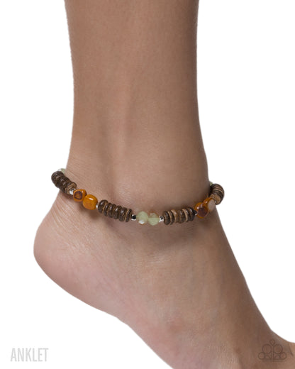 Beaded anklet on a foot against a white background
