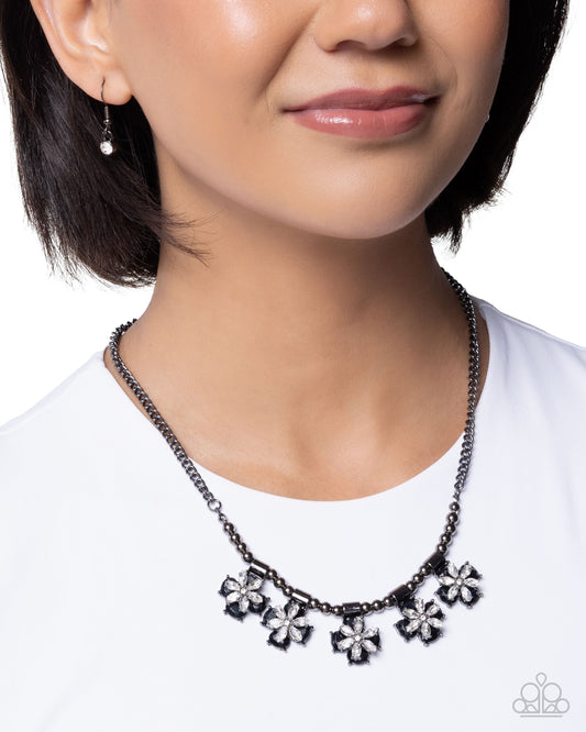 Necklace with floral pendants worn by a model on a white background