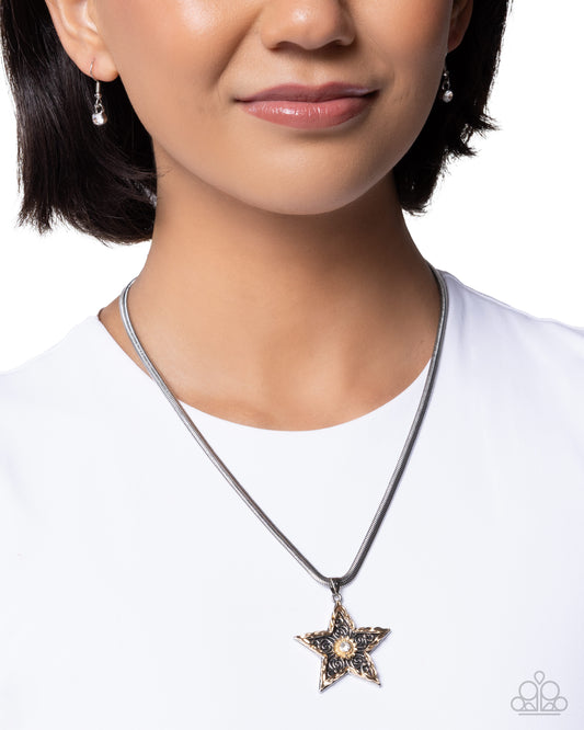 Star-shaped pendant necklace worn by a model on a white background