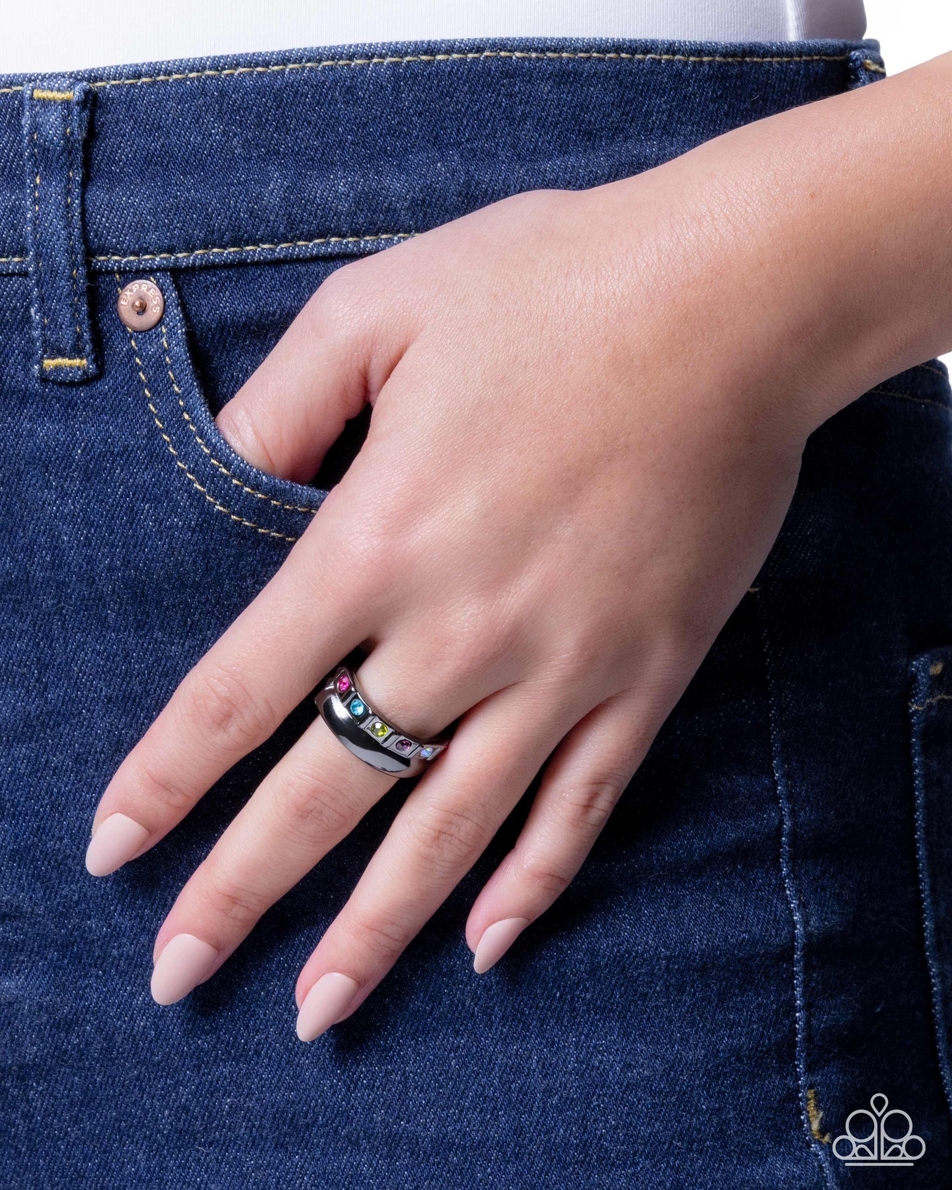 Hand wearing a ring on blue denim background