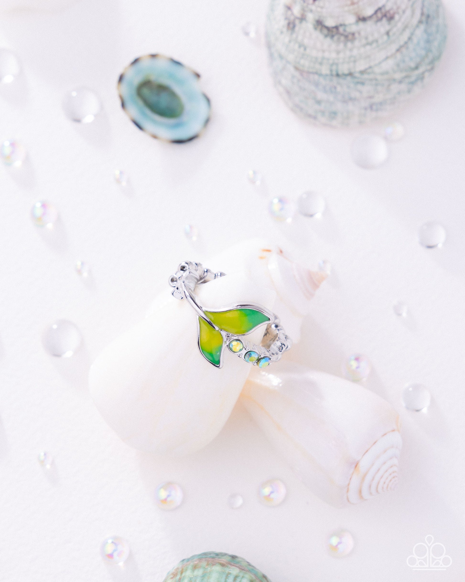 Decorative ring with green and yellow design on a white surface with decorative elements.