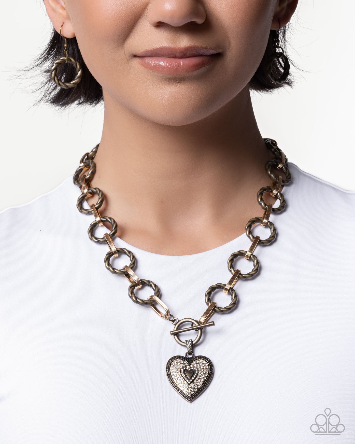 Necklace with a heart charm worn by a person on a white background