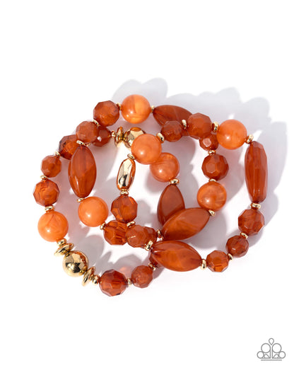 A multi-strand beaded bracelet set featuring orange and amber carnelian beads with gold spacer accents, displayed on a clean white background.