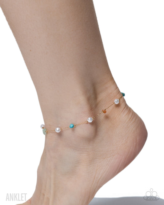 Ankle bracelet with colorful beads on a foot against a white background