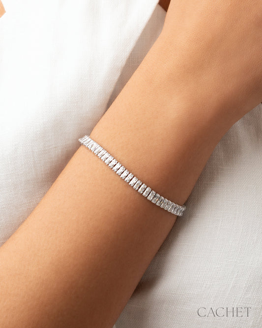 Silver bracelet on a person's wrist with 'Cachet' branding.