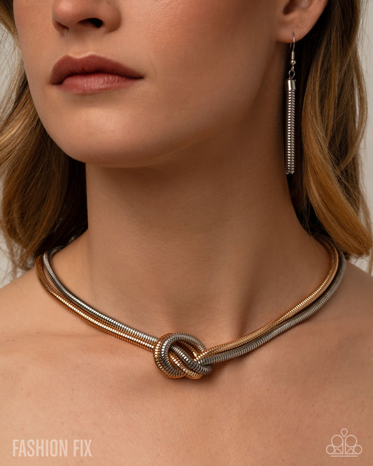 Necklace with a knot design worn by a person, with 'Fashion Fix' branding.