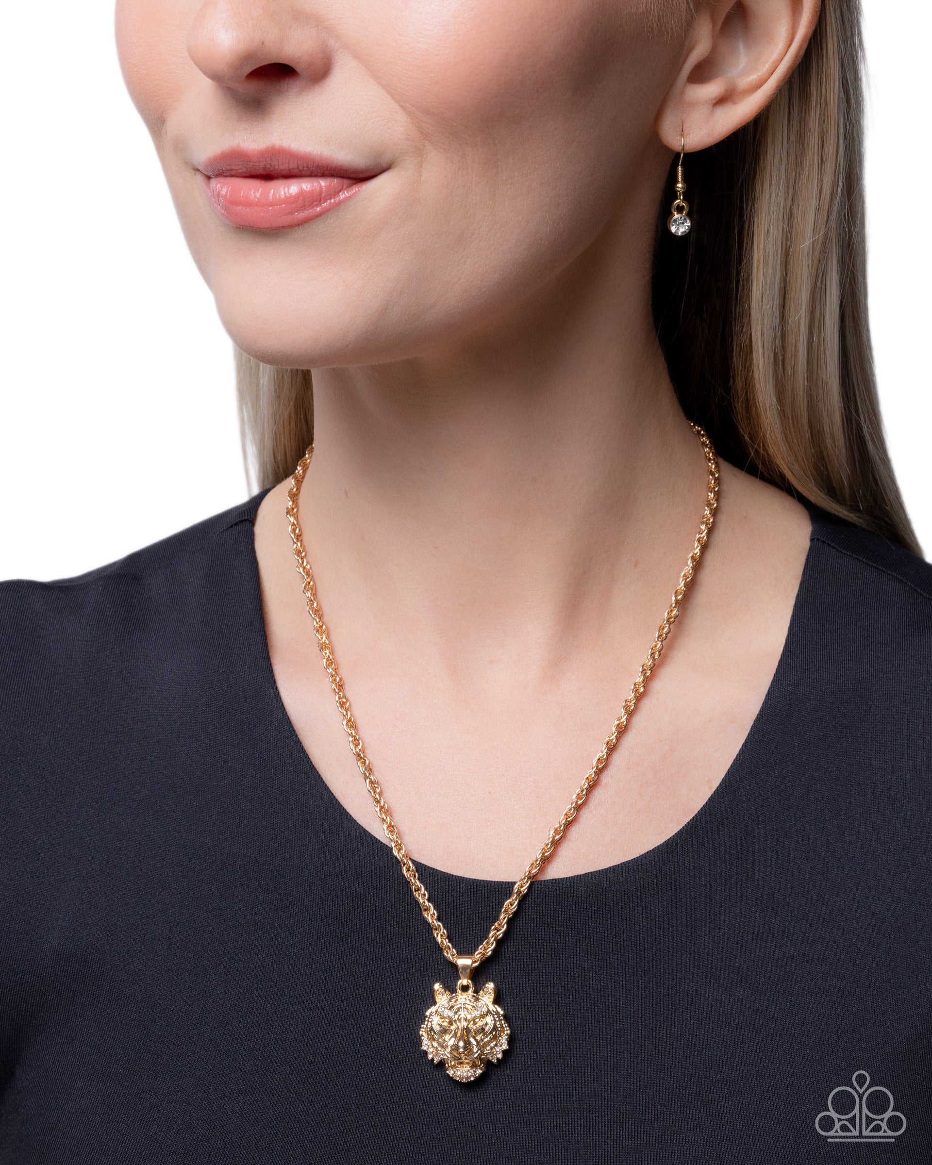 Woman wearing a gold necklace and earrings on a plain background