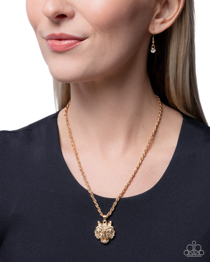 Woman wearing a gold necklace and earrings on a plain background