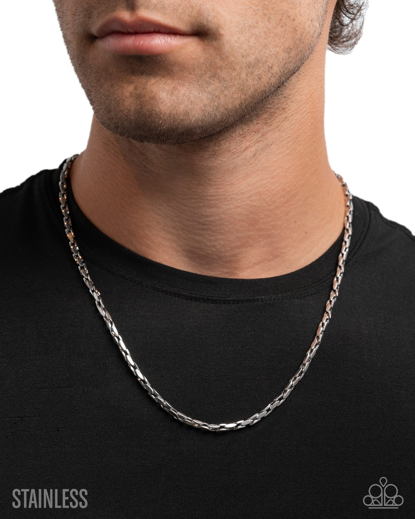 Silver chain necklace worn by a person on a black background