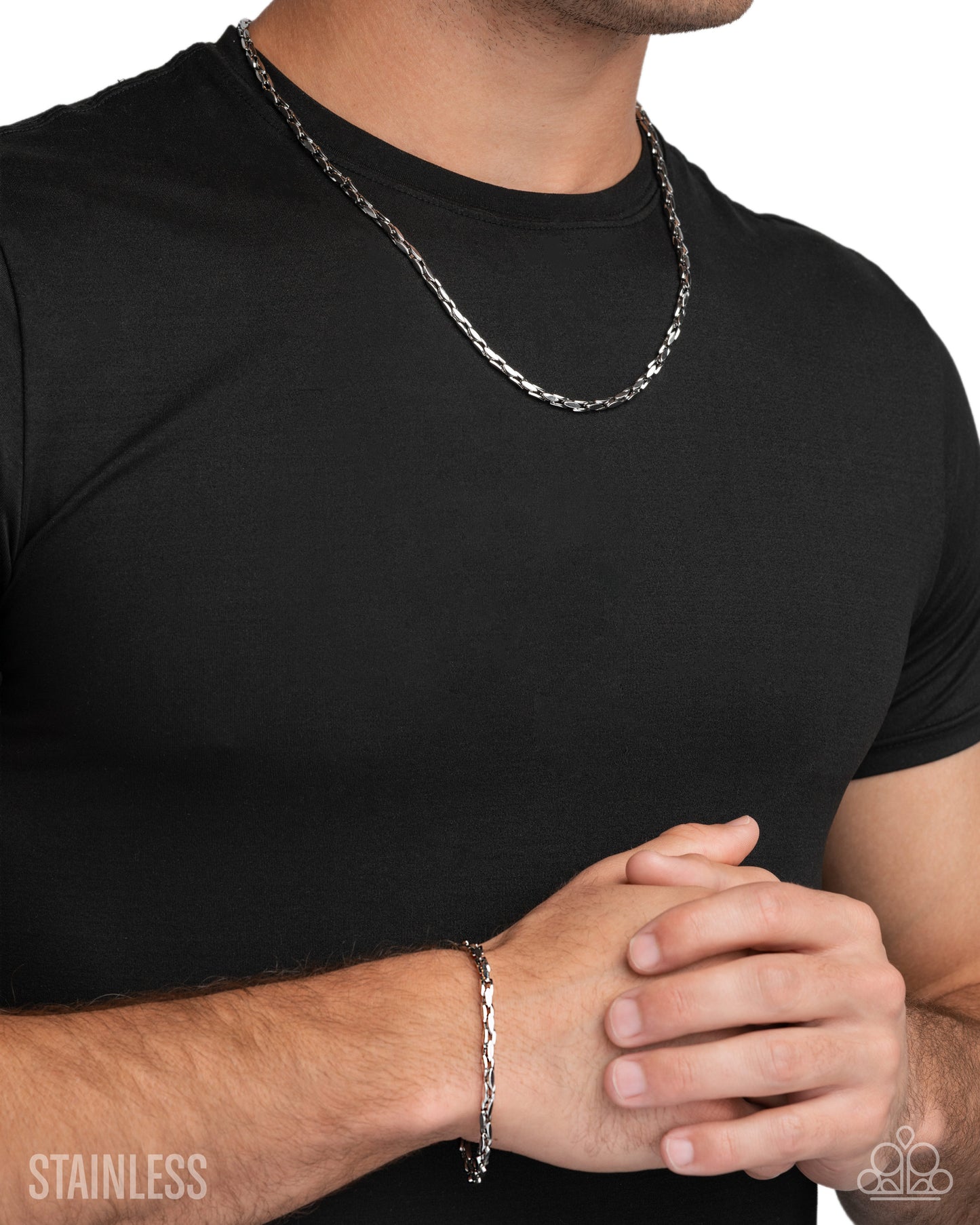 Man wearing a black t-shirt with a silver chain necklace and bracelet on a white background