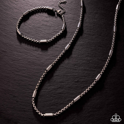Silver bracelet and necklace set on a dark textured surface