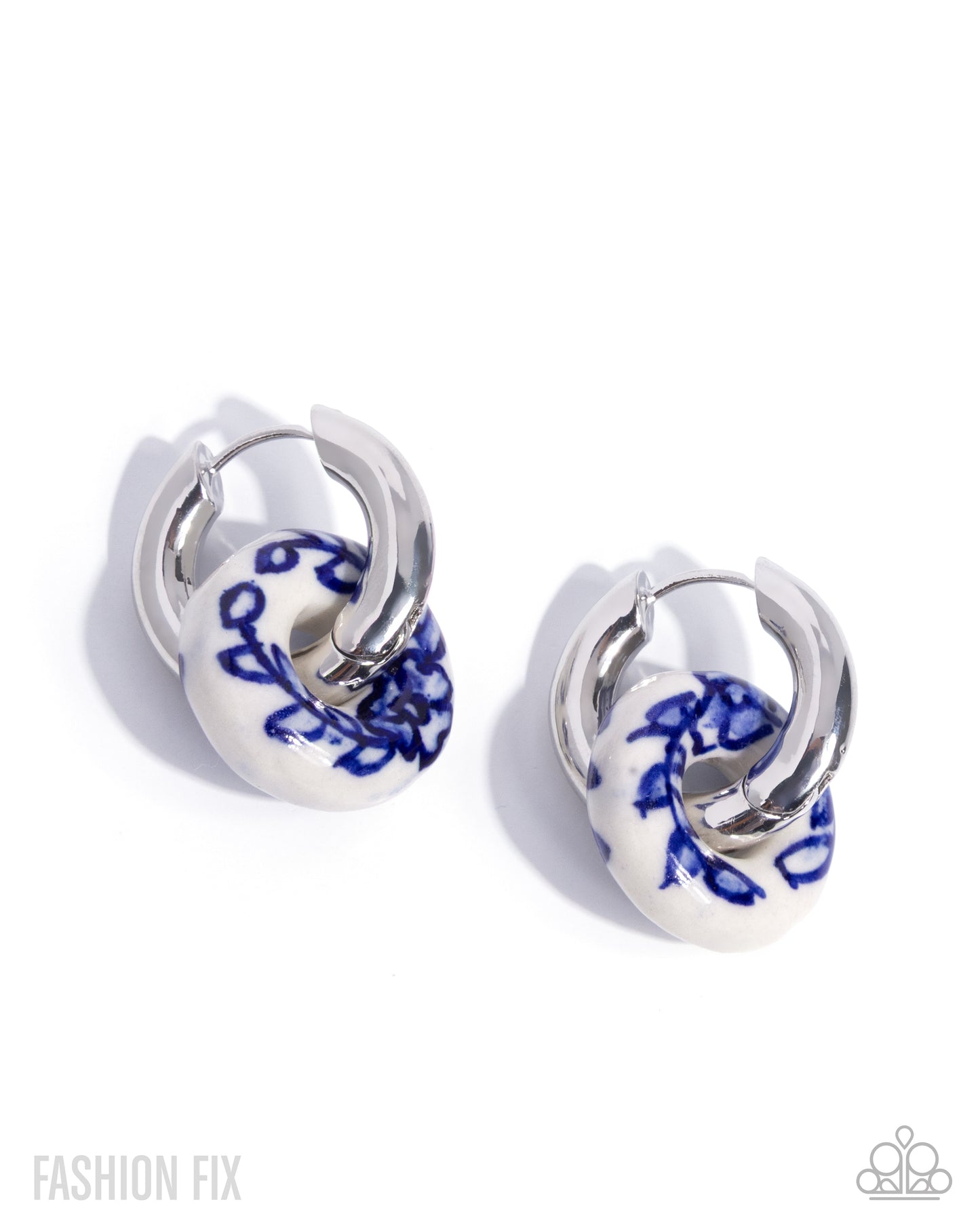 Pair of hoop earrings with blue floral design on white background