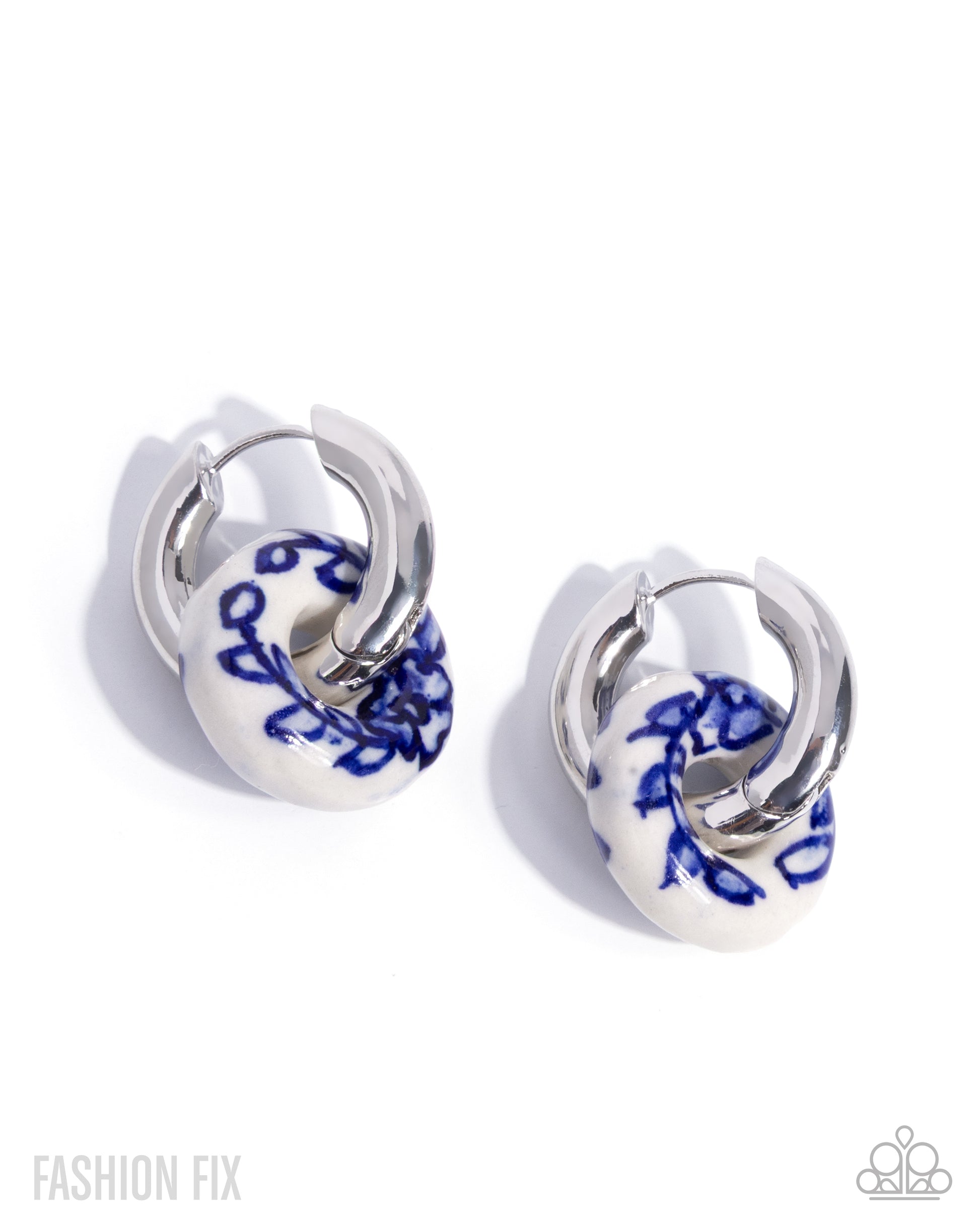 Pair of hoop earrings with blue floral design on white background