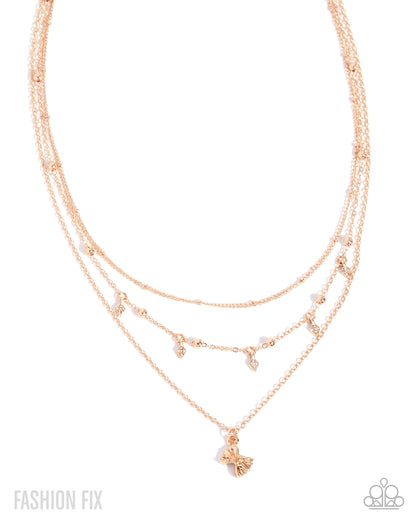 A rose gold multi-layered necklace with delicate chains, small bead accents, and a butterfly pendant, shown on a white background with 'FASHION FIX' text in the corner.