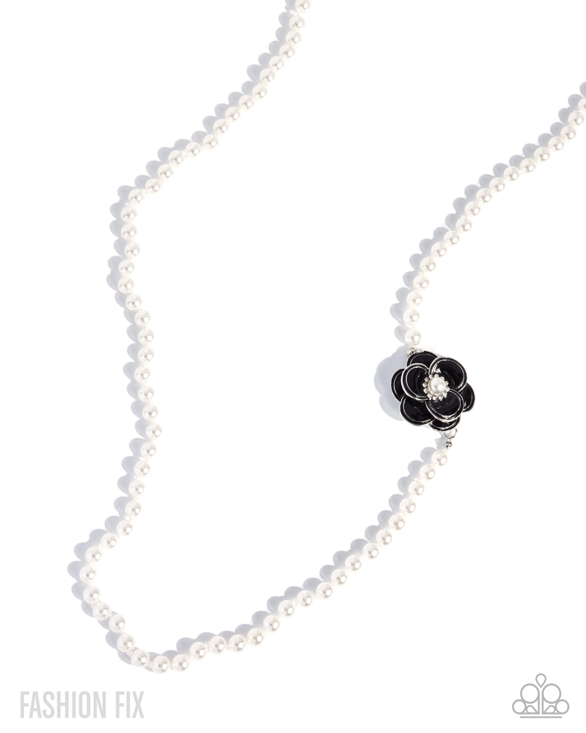 A white pearl necklace with a black flower-shaped charm featuring a clear crystal center, displayed on a clean white background with soft shadows.