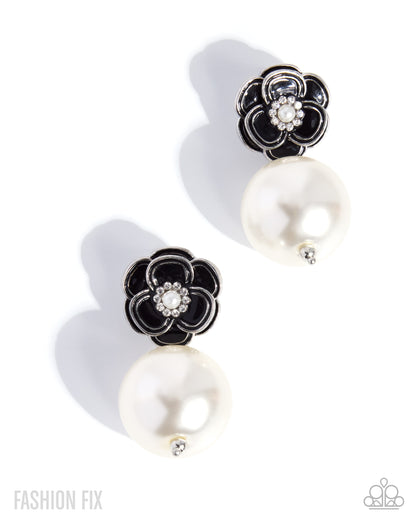 A pair of black and white flower-shaped earrings with large white pearl drops and a small crystal center, shown on a white background with soft shadows.