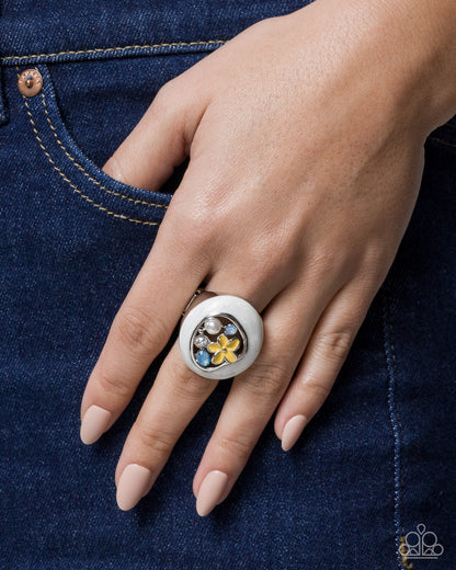 Close-up of a hand wearing a decorative ring on blue denim fabric