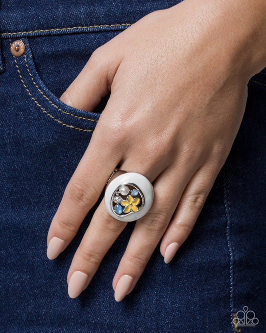 Close-up of a hand wearing a decorative ring on blue denim fabric